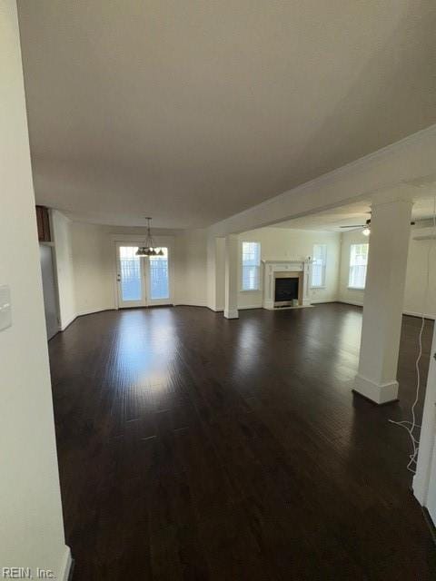 unfurnished living room with a fireplace and dark wood finished floors