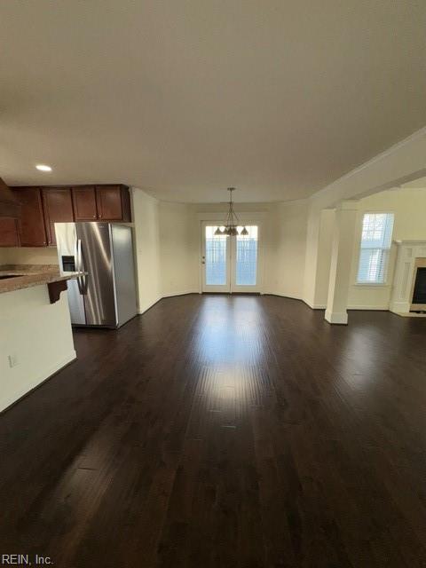 unfurnished living room with dark wood-type flooring, a fireplace, and a wealth of natural light