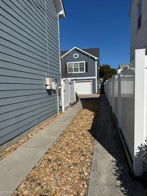 view of side of home featuring a garage and fence