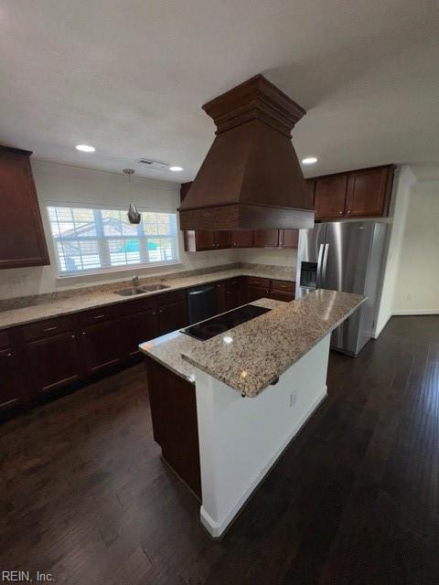 kitchen featuring dark wood-type flooring, island range hood, a sink, and black appliances