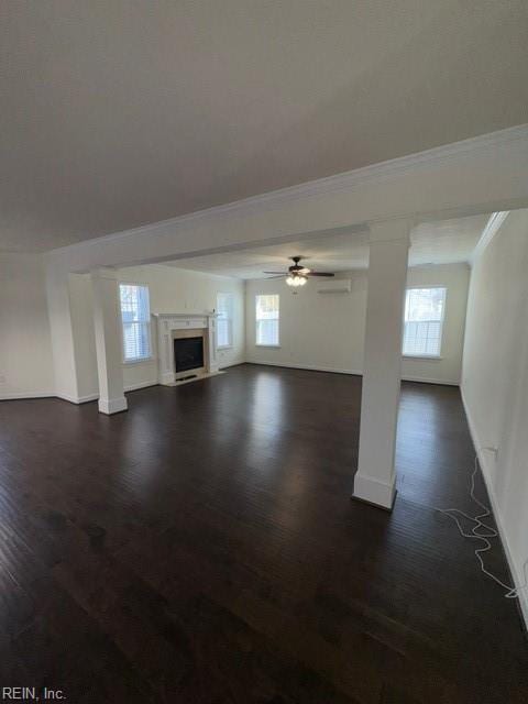 unfurnished living room with crown molding, dark wood-style flooring, a fireplace, and baseboards