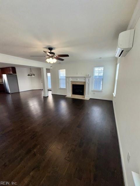 unfurnished living room with dark wood-style flooring, a fireplace with flush hearth, a ceiling fan, baseboards, and an AC wall unit