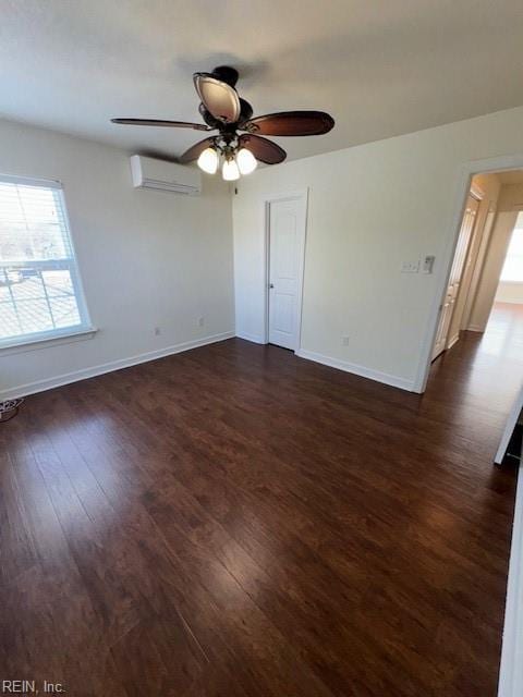 empty room featuring a ceiling fan, dark wood-style flooring, baseboards, and a wall mounted AC