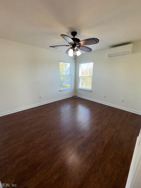 spare room with dark wood-type flooring, a wall mounted AC, and baseboards