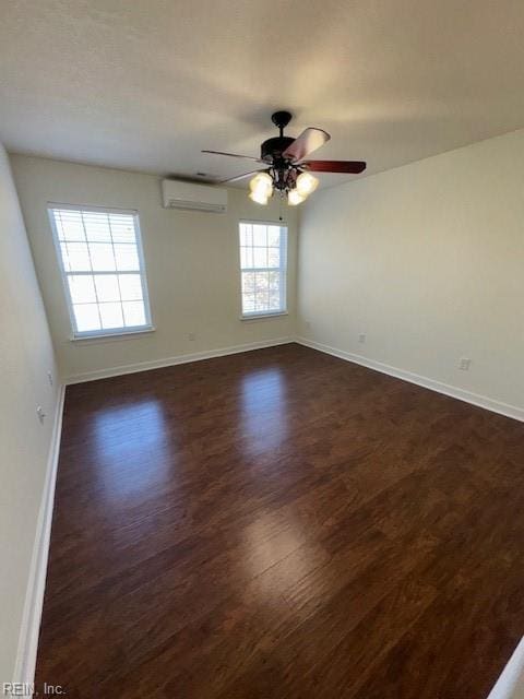 unfurnished room featuring ceiling fan, dark wood finished floors, baseboards, and a wall mounted AC