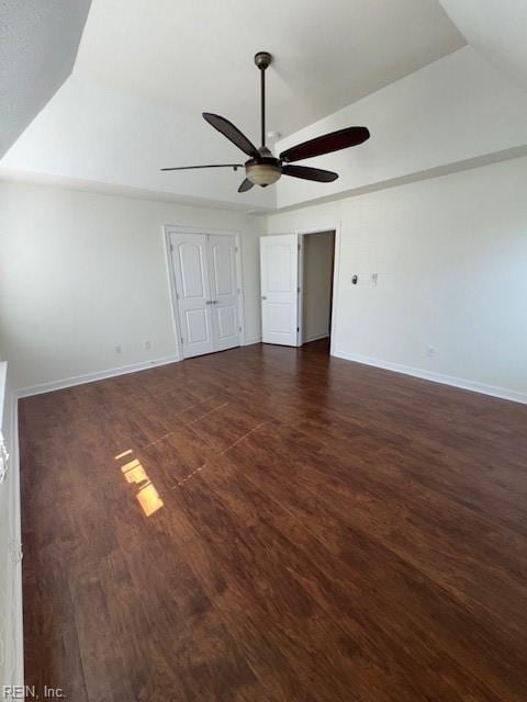 unfurnished bedroom featuring ceiling fan, baseboards, and dark wood-style flooring