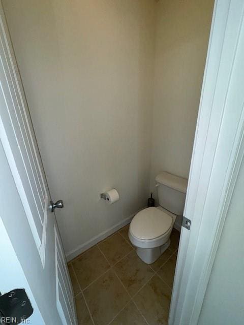 bathroom featuring baseboards, toilet, and tile patterned floors