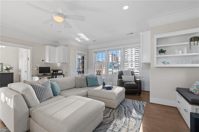 living room with a ceiling fan, crown molding, and wood finished floors