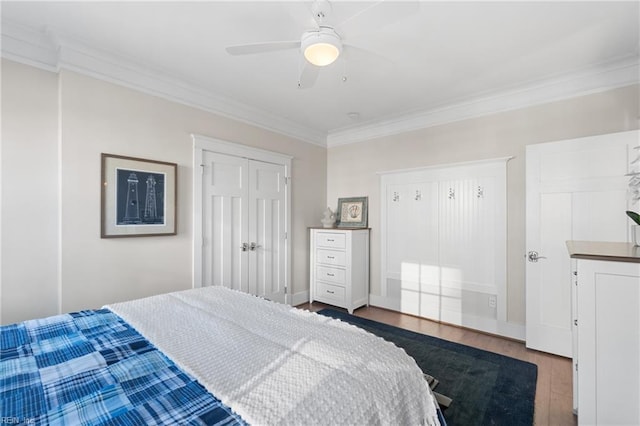 bedroom featuring ceiling fan, wood finished floors, baseboards, ornamental molding, and a closet