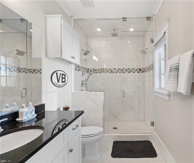 full bath with a stall shower, baseboards, vanity, and toilet