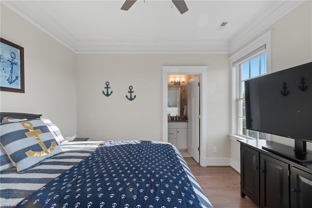 bedroom with ornamental molding, visible vents, baseboards, and wood finished floors