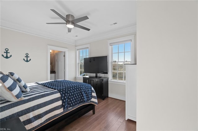 bedroom with baseboards, visible vents, ceiling fan, ornamental molding, and wood finished floors