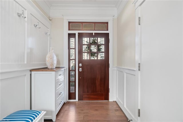 foyer entrance with ornamental molding, wainscoting, a decorative wall, and wood finished floors