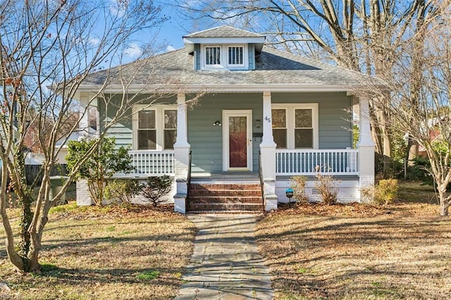 bungalow-style home featuring covered porch and roof with shingles