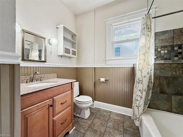 bathroom with wooden walls, shower / bath combo, toilet, a wainscoted wall, and vanity