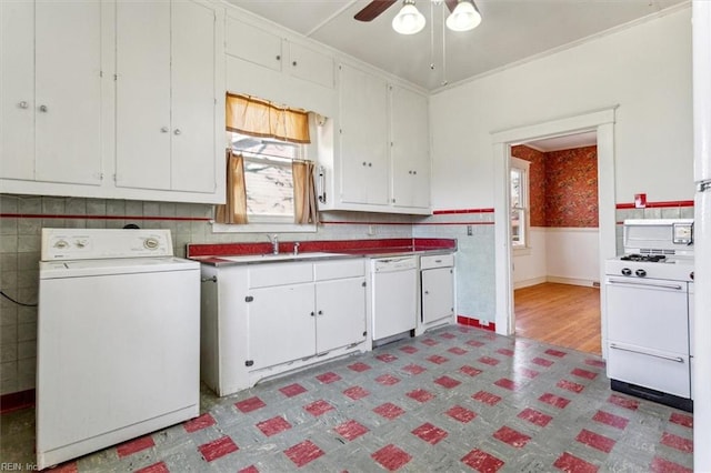 kitchen with washer / dryer, dark floors, white appliances, and wainscoting