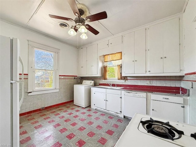 kitchen with white appliances, visible vents, washer / clothes dryer, light floors, and white cabinetry