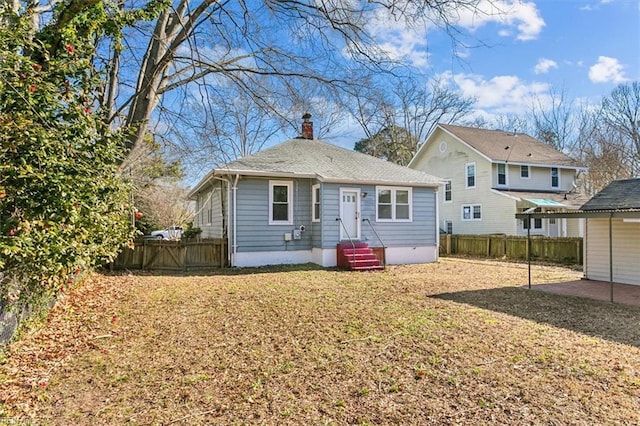 rear view of property featuring a yard, a chimney, entry steps, a patio area, and fence