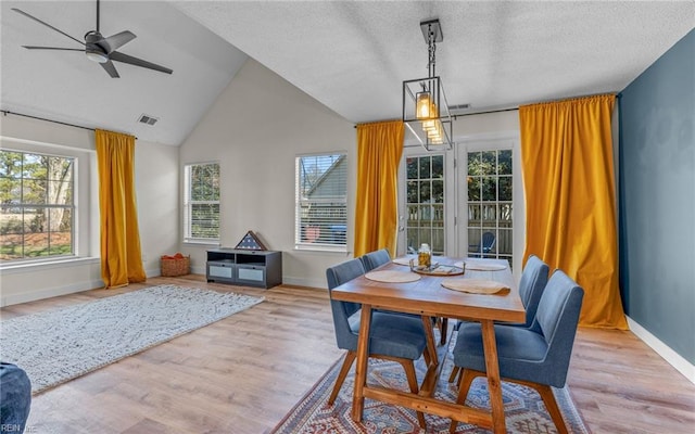 dining area featuring lofted ceiling, visible vents, baseboards, and wood finished floors