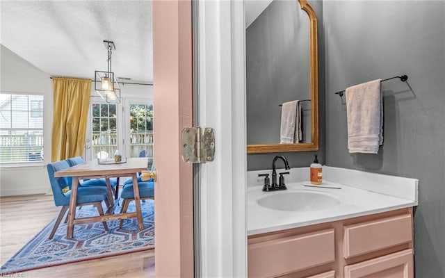 bathroom featuring baseboards, wood finished floors, and vanity