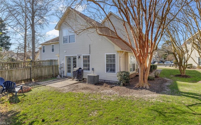 back of house featuring cooling unit, a fire pit, fence, a yard, and a patio area