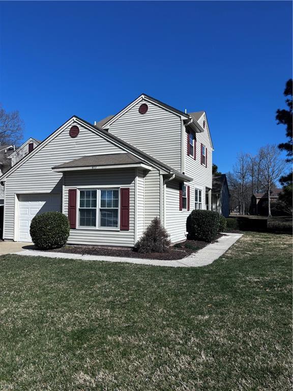 view of property exterior with a garage and a yard