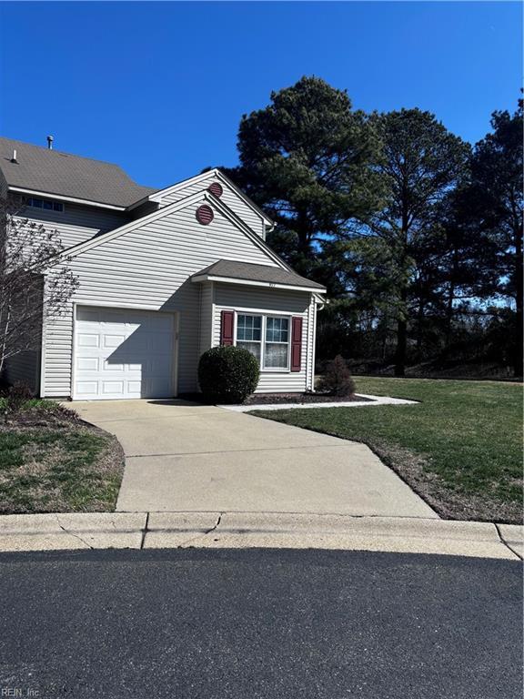 traditional home with concrete driveway and a front lawn