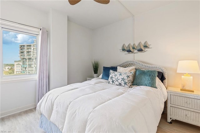 bedroom featuring ceiling fan, baseboards, and wood finished floors