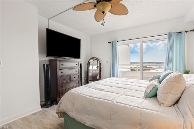 bedroom with baseboards, ceiling fan, light wood-style flooring, and a textured ceiling