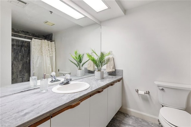 bathroom featuring visible vents, a shower with shower curtain, toilet, vanity, and baseboards