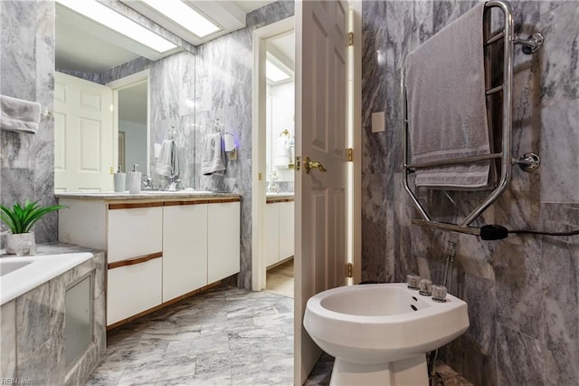 bathroom with marble finish floor, a bidet, and vanity