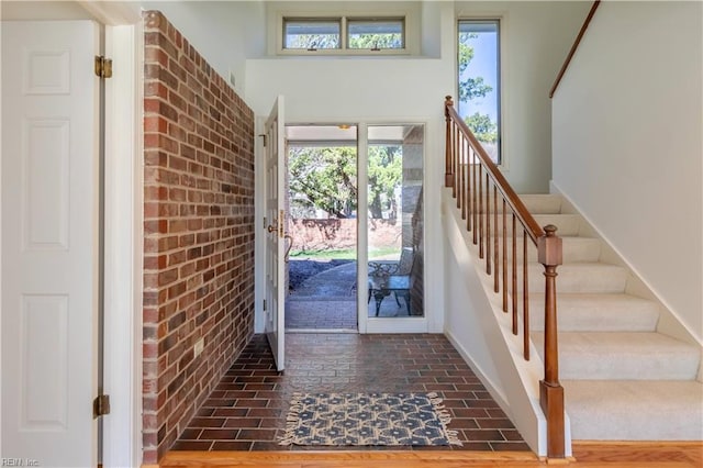 doorway to outside with brick floor and stairs