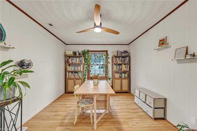 dining area with ornamental molding, light wood finished floors, and a ceiling fan