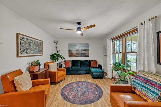 living area with a ceiling fan and wood finished floors