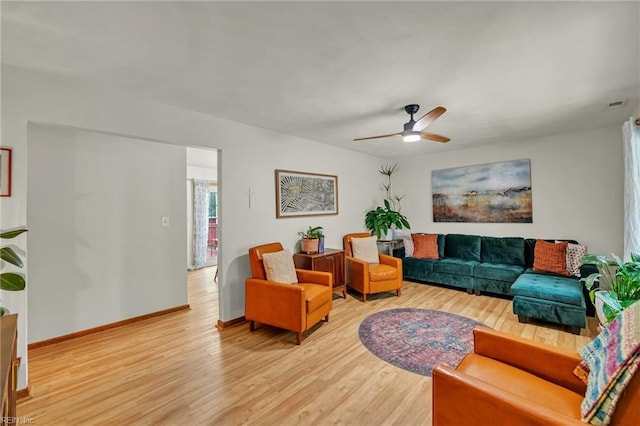 living room featuring baseboards, ceiling fan, visible vents, and light wood-style floors