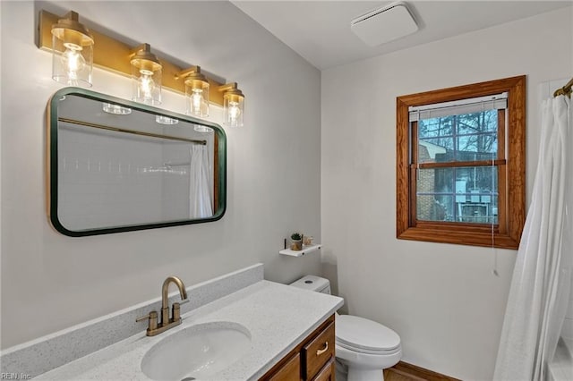 bathroom featuring toilet, curtained shower, and vanity