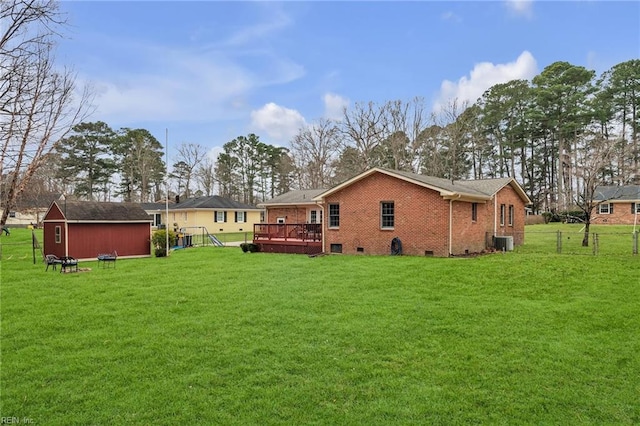 back of house featuring central AC, a yard, a deck, and brick siding