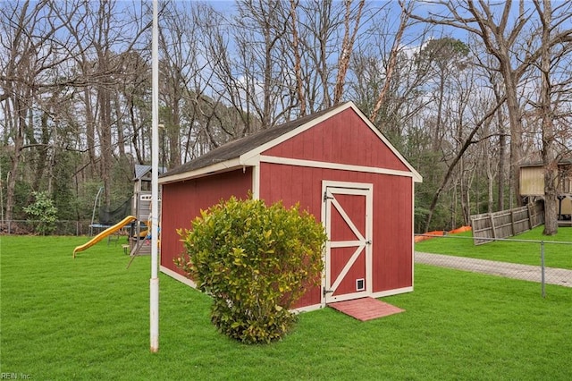 view of shed with a playground and fence