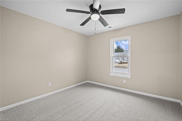 carpeted empty room featuring ceiling fan, visible vents, and baseboards