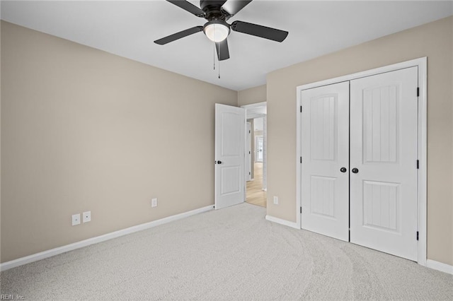 unfurnished bedroom with carpet floors, a closet, a ceiling fan, and baseboards