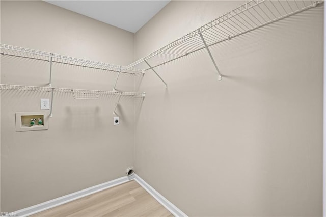 washroom featuring washer hookup, light wood finished floors, electric dryer hookup, laundry area, and baseboards