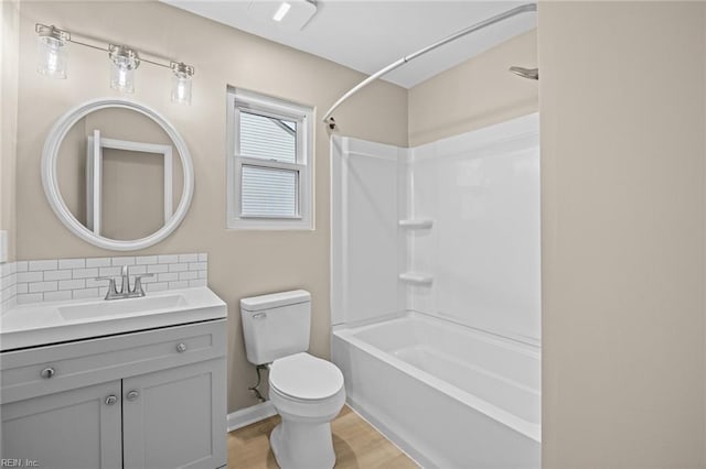 full bath with bathtub / shower combination, toilet, decorative backsplash, vanity, and wood finished floors