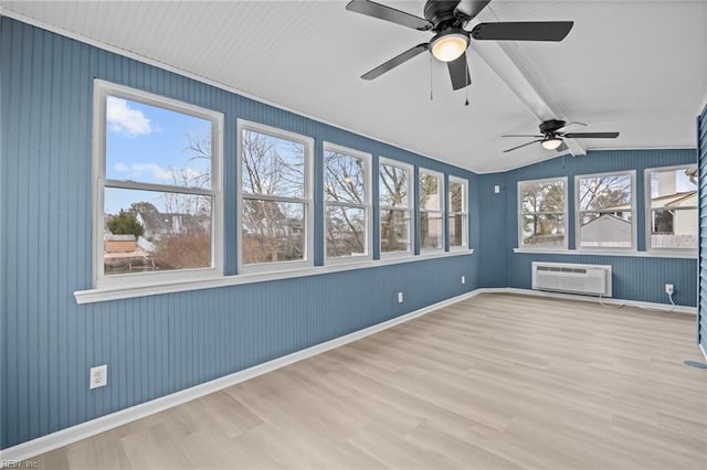 unfurnished room featuring a wall mounted air conditioner, plenty of natural light, and wood finished floors