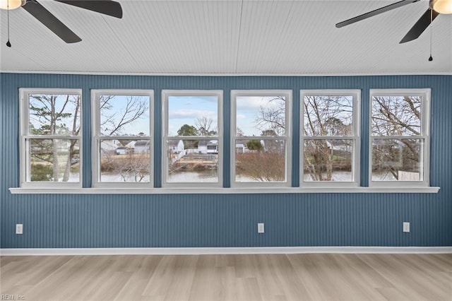 unfurnished sunroom with plenty of natural light and a ceiling fan