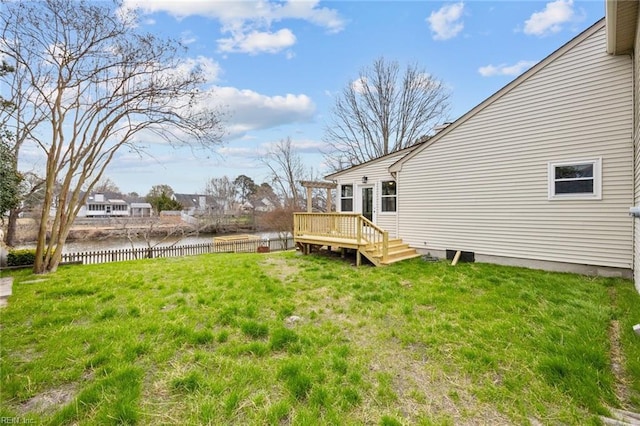 view of yard featuring a deck with water view and fence