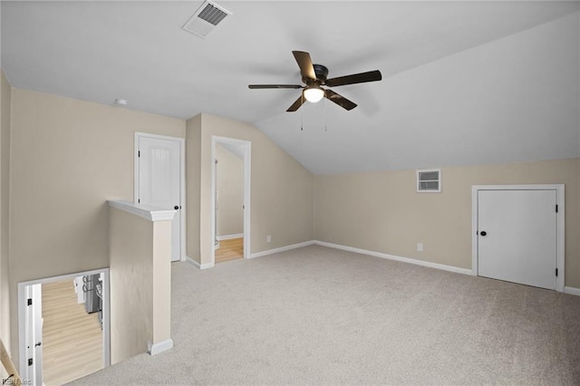 bonus room with light colored carpet, visible vents, and baseboards