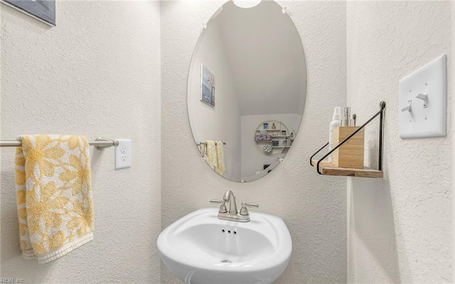 bathroom with a textured wall and a sink