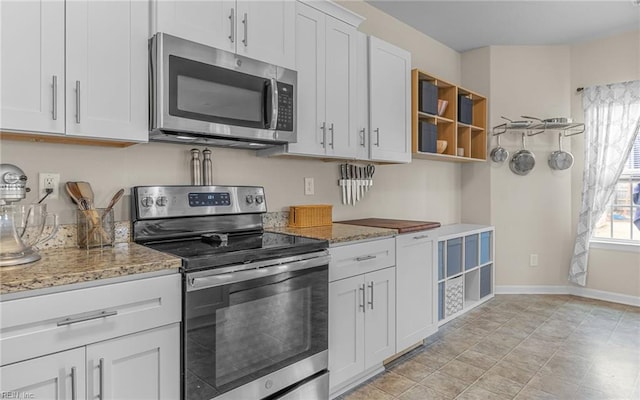 kitchen with stainless steel appliances, plenty of natural light, and light stone countertops