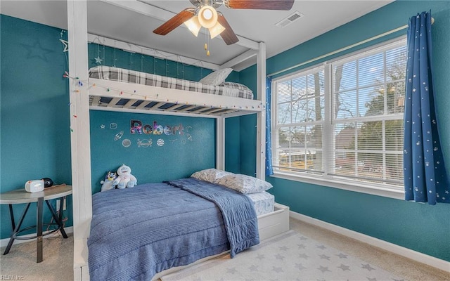 carpeted bedroom featuring a ceiling fan, visible vents, and baseboards