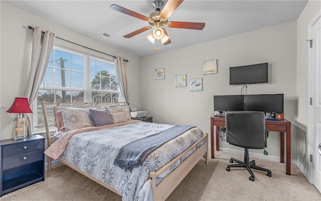 carpeted bedroom featuring a ceiling fan, visible vents, and baseboards